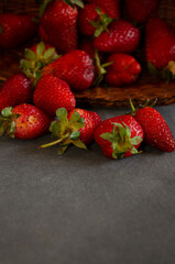 strawberries in a basket falling on gray table