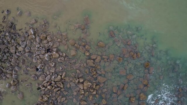 Top-down aerial Slow pan close up left to right surf right to left Waves Crashing on Pacific Shores Drone