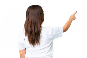 Middle age volunteer woman over isolated chroma key background pointing back with the index finger