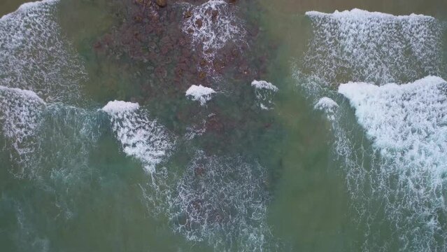 Top-down aerial Static-surf-right to left Pacific Coast Drone Video