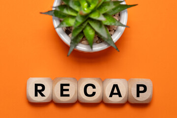 Recap symbol, Conceptual word ,Recap, on wooden cubes, Beautiful orange background with succulents,...