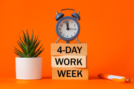 Symbol of a 4-day working week. Desk with wooden blocks with the words 4-day work week, seculant, pen, beautiful orange background. Copy space. Business concept, change from 5 to 4 day work week