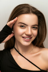 Obraz premium Portrait of a beautiful girl with a model look. Close-up portrait of a girl with laminated and painted eyebrows. Smiling beautiful girl. Female beauty natural make up young model face close up beauty.