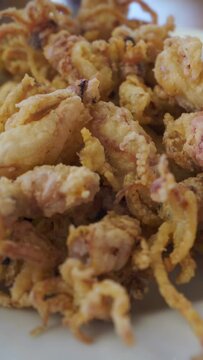 Spanish tapas: Plate of deep fried squids or Chipirones with lemon.