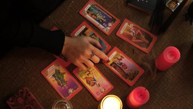 A woman shuffles a Tarot deck, preparing for a consultation to predict future fate. Fortune teller, medium, fortune telling cards.