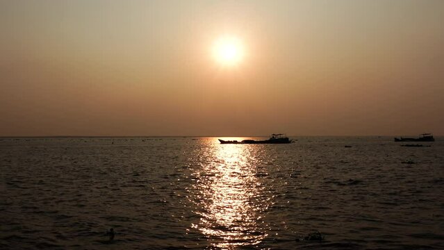 A cargo boat is moving on the Padma River at sunset. Evening river view of golden water.