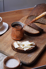 a loaf of black bread cut into pieces. Rye bread with butter.