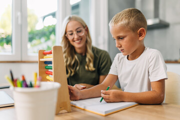 Obraz premium Cute Caucasian preschooler is learning counting with abacus.
