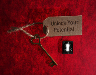 Gold vintage key with Unlock Your Potential paper label and  ornate bright keyhole lock