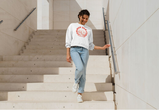 Mockup of woman wearing customizable sweatshirt coming down steps