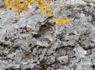Natural stone walls are the entrance to a cave on a steep cliff of a mountain canyon, soft phokus.