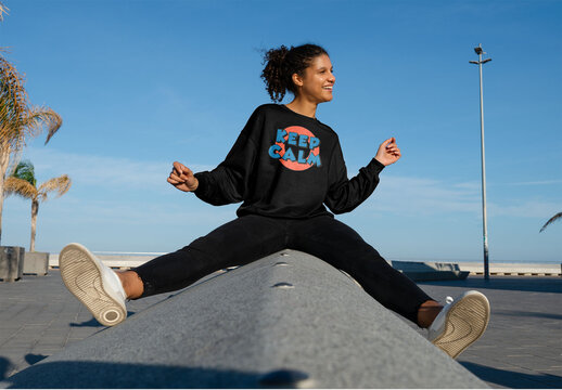 Mockup of woman wearing customizable sweatshirt on wall, legs apart