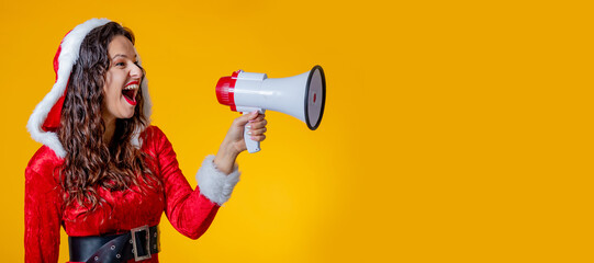 young woman wearing santa claus costume isolated shouting with megaphone