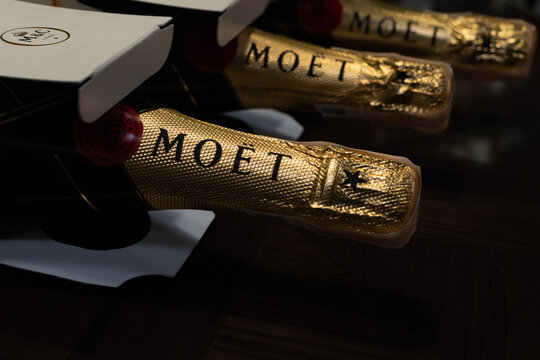 Bottles and branded boxes of France champagne Moet & Chandon Imperial Brut close-up on dark background. Ukraine, Zhytomyr, November, 20, 2023