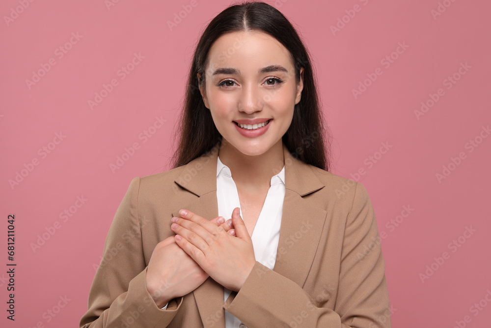 Poster thank you gesture. beautiful grateful woman with hands on chest against pink background