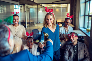 Business people drinking champagne during new year and Christmas holidays at the office