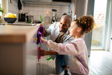 Father and daughter cleaning kitchen