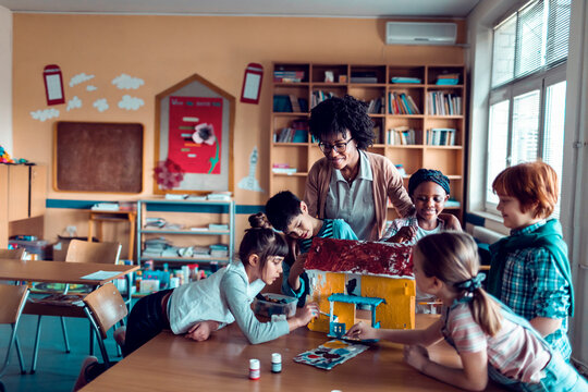 Children doing school art project with teacher in classroom