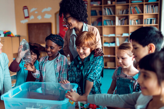 Children learning how to recycle plastic in elementary classroom