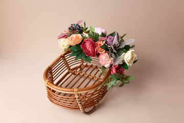 Fototapeta na wymiar wooden basket decorated with flowers. basket for a newborn photo shoot. rose decorations