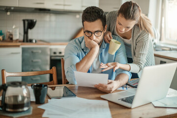 Young couple reading bad financial report having financial debt at home