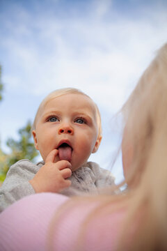 Outdoor portrait of baby sticking out tongue 