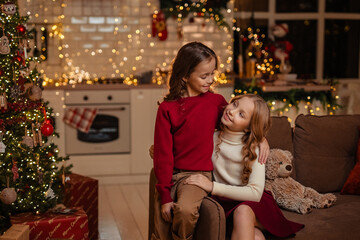 Fototapeta na wymiar teenage sisters twins at home in the kitchen waiting for the New Year
