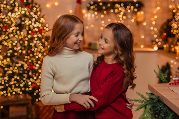  teenage sisters twins at home in the kitchen waiting for the New Year