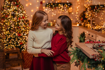  teenage sisters twins at home in the kitchen waiting for the New Year