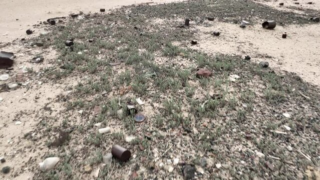 Aerial shot looking down at trash on the cracked surface of a dry lake in Navada
