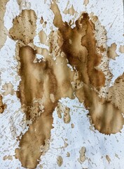 Abstract coffee grunge background. Brown coffee stains on white paper with copy space. Dirty paper with coffee drops. 