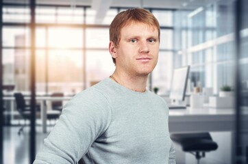 Happy business man standing in modern office.