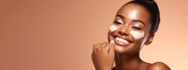 Portrait of smiling African American young woman applies cream to face. Advertisement of cosmetic cream. Skinimalism.