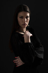 Portrait of a confident woman dressed in black, exuding a strong and serious elegance with a thoughtful expression