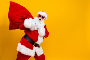 Fototapeta na wymiar Photo of grandfather santa claus bring bag to deliver big bag from north pole shopping advert merry xmas isolated on yellow color background