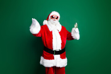 Fototapeta na wymiar Photo of cheerful positive claus wear red costume drinking champagne telling christmas wishes isolated green color background
