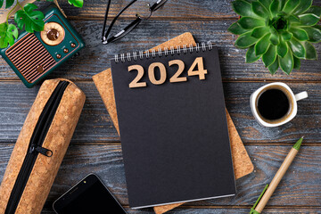 .New year resolutions 2024 on desk. 2024 goals list with notebook, coffee cup, plant on wooden table. Resolutions, plan, goals, action, checklist, idea concept. New Year 2024 resolutions. Copy space