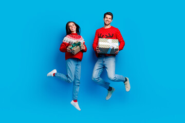 Full length photo of two satisfied optimistic people flying holding present boxes on christmas eve...