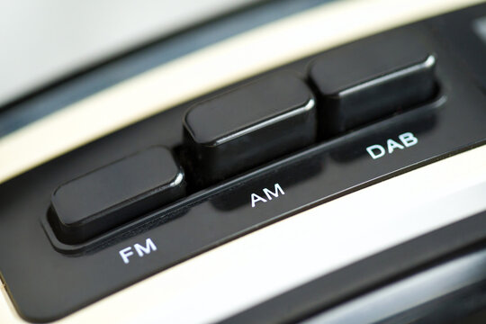 Close up of Three vintage radio buttons, FM, AM, DAB. Black and silver tones