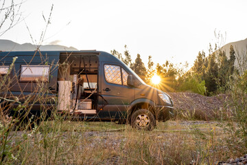 Campervan 4x4 seen from the side with the sun behind it