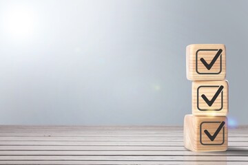 Check mark for jobs list on wooden blocks.