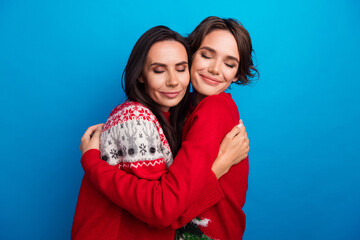 Photo of two girls hugging on new year party isolated blue color background