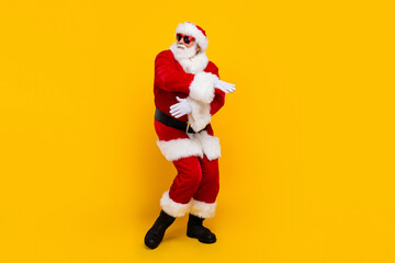 Full length portrait of excited crazy aged santa have good mood dancing empty space christmas event isolated on yellow color background