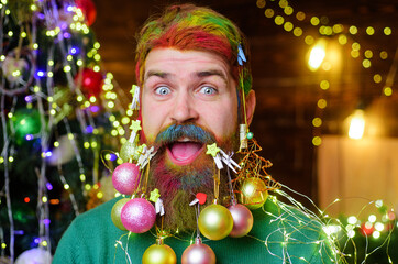 Christmas or New year barbershop. Bearded man with decorated beard with Christmas balls. Smiling...