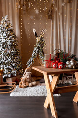 Children's room decorated in Christmas style. Wooden sleigh, gifts and hut for children to play.