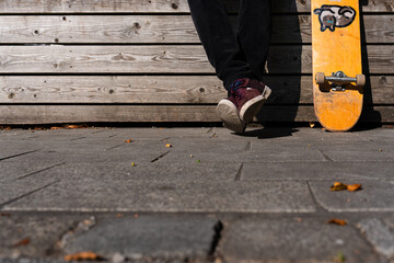 legs of a man sitting with his skateboard