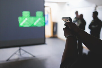 Process of shooting target at the shooting rifle range, women practicing with hand gun pistol at...