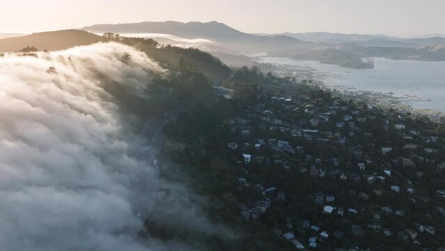 Drone shot of Sausalito hills and San Franco suburban in morning fog, California, West coast, USA. Picturesque view of waterfront houses on the San Francisco Bay in mist at the sunrise, 4k footage
