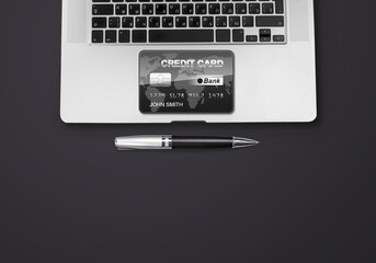 Black classic credit card on table with laptop