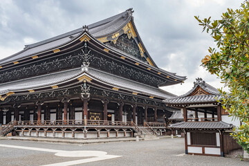 Fototapeta premium Beautiful view of the majestic temple Higashi Honganji in Kyoto, Japan. Very elaborate construction of wood and golden decorations on this temple. 